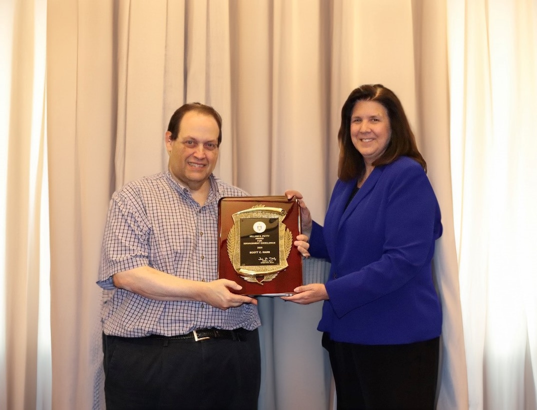 man and woman holding award plaque