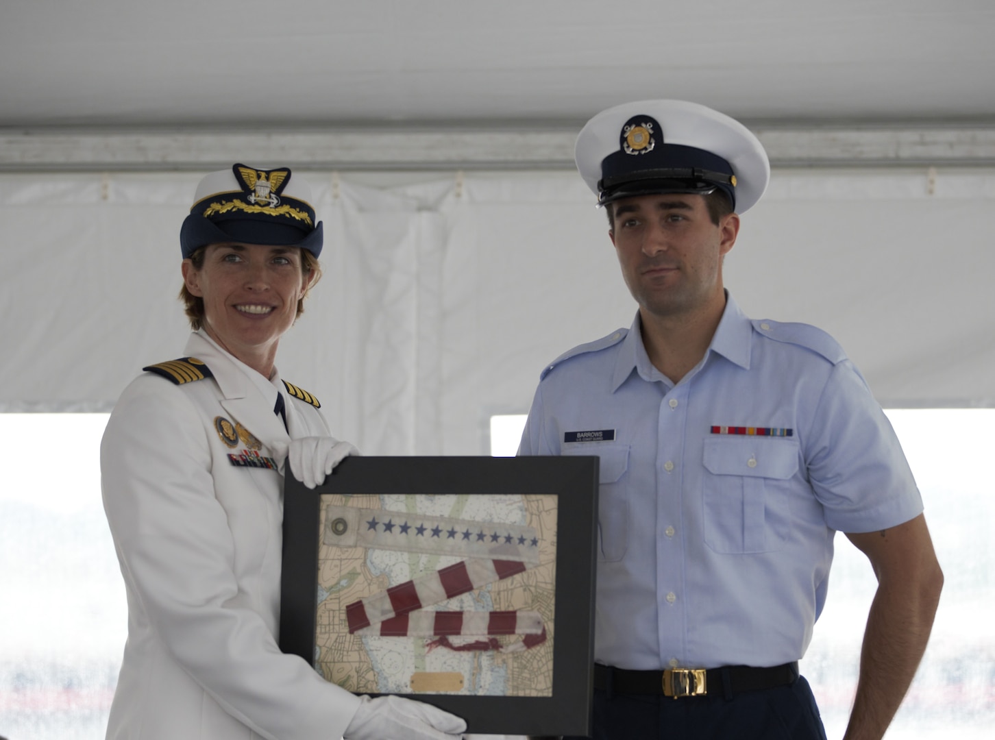U.S. Coast Guard Capt. Anne O’Connell, left, out-going commanding officer of the USCGC Campbell (WMEC 909) receives the commissioning pennant that was flown on the mast during her time as commanding officer by crew member, Fireman Joseph Barrows, during a change of command ceremony, June 9, 2023, at Naval Station Newport. Rear Adm. Laura Dickey, deputy commander of Coast Guard Atlantic Area, presided over the ceremony. (U.S. Coast Guard photo by Petty Officer 2nd Class Eric Desirey)