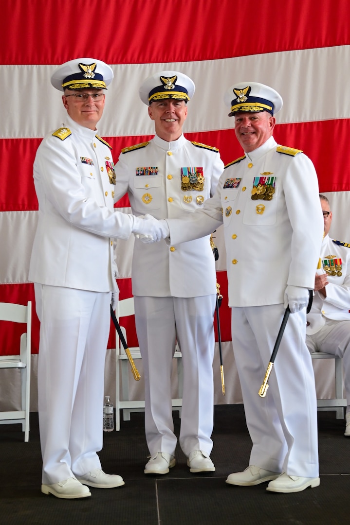 Vice Adm. Kevin Lunday, Coast Guard Atlantic Area Commander, oversees Rear Adm. Brendan McPherson, the former Seventh District Commander, and Rear Adm. Douglas Schofield, the Seventh District Commander, render a salute during a change of command ceremony at Air Station Miami in Opa-locka, Florida, June 9, 2023. During the ceremony Schofield relieved McPherson as the Seventh District Commander and Director of Department of Homeland Security Joint Task Force - Southeast. (U.S. Coast Guard photo by Petty Officer 3rd Class Eric Rodriguez)