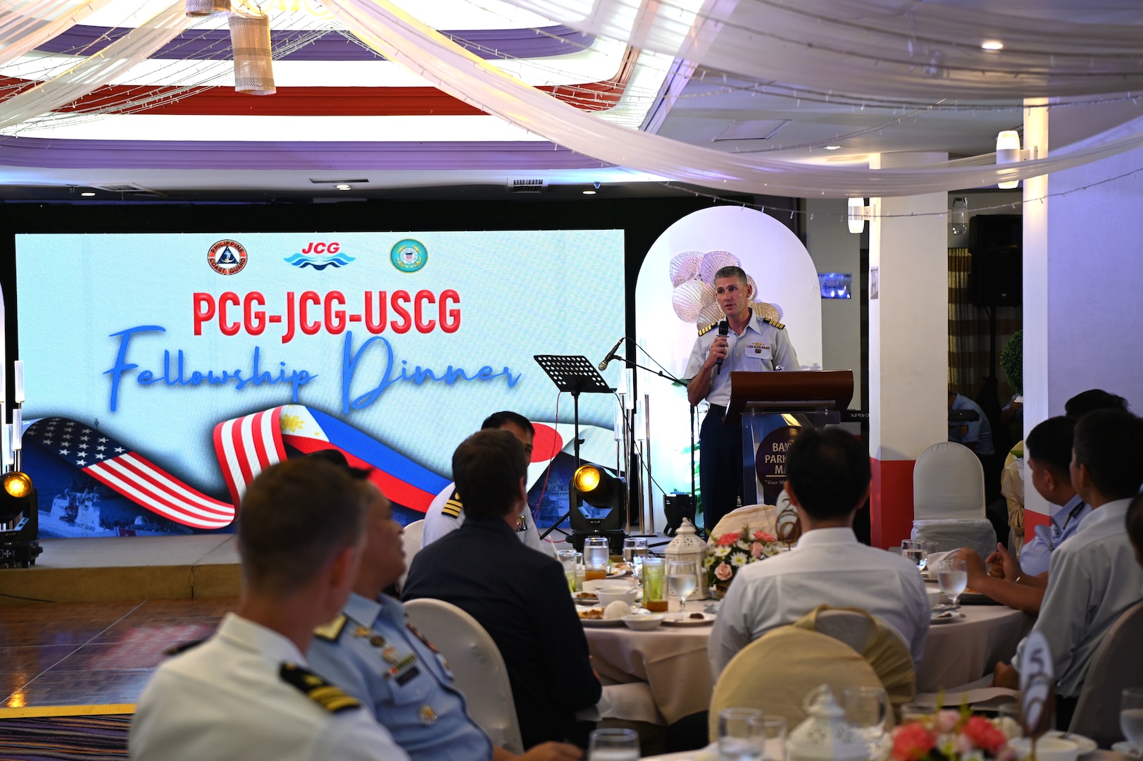 Capt. Brian Krautler, U.S. Coast Guard Cutter Stratton's (WMSL 752) commanding officer, speaks to servicemembers from the Japan Coast Guard Vessel Akitsushima (PLH 32) and the Philippine Coast Guard during a fellowship dinner in Manila, Philippines, June 1, 2023. Stratton deployed to the Western Pacific to engage with regional allies and partner nations, reinforcing a rules-based order and maritime governance to promote a free and open Indo-Pacific. (U.S. Coast Guard photo by Chief Petty Officer Matt Masaschi)
