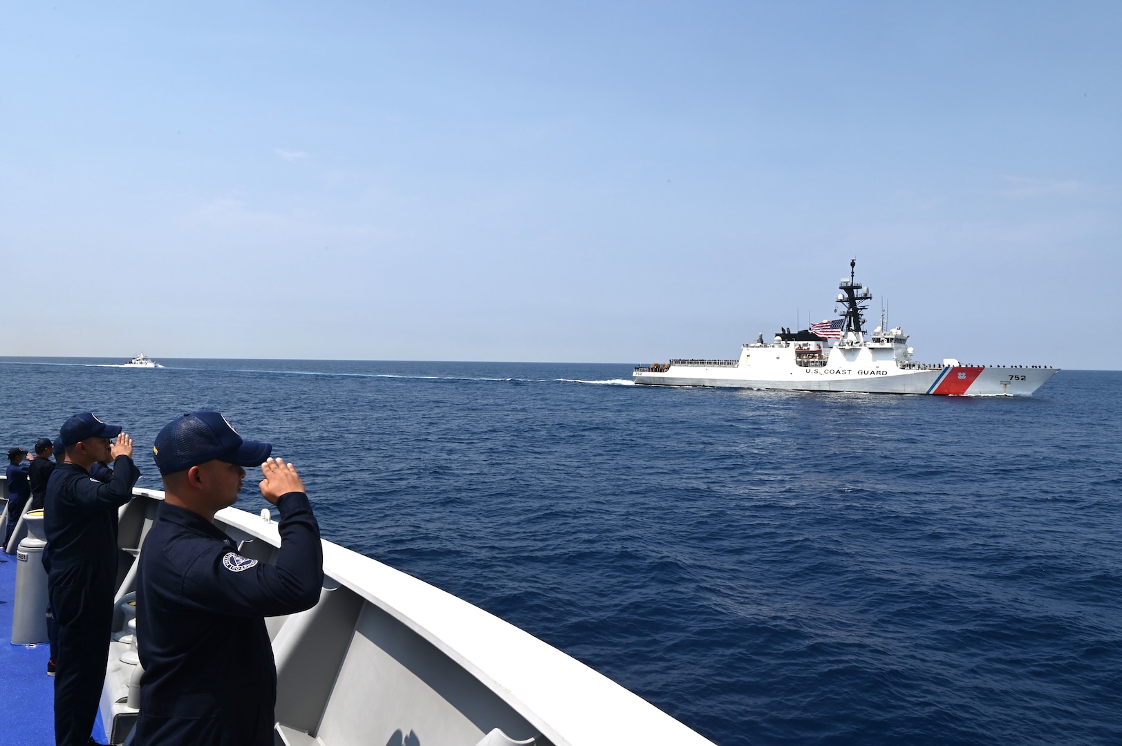 Crewmembers aboard the Philippine Coast Guard Vessel Melchora Aquino (MRRV-9702) render hand salutes as the U.S. Coast Guard Cutter Stratton (WMSL 752) approaches in the South China Sea, June 7, 2023. Stratton deployed to the Western Pacific to conduct engagements with regional allies and partner nations, reinforcing a rules-based order in the maritime domain.  (U.S. Coast Guard photo by Chief Petty Officer Matt Masaschi)