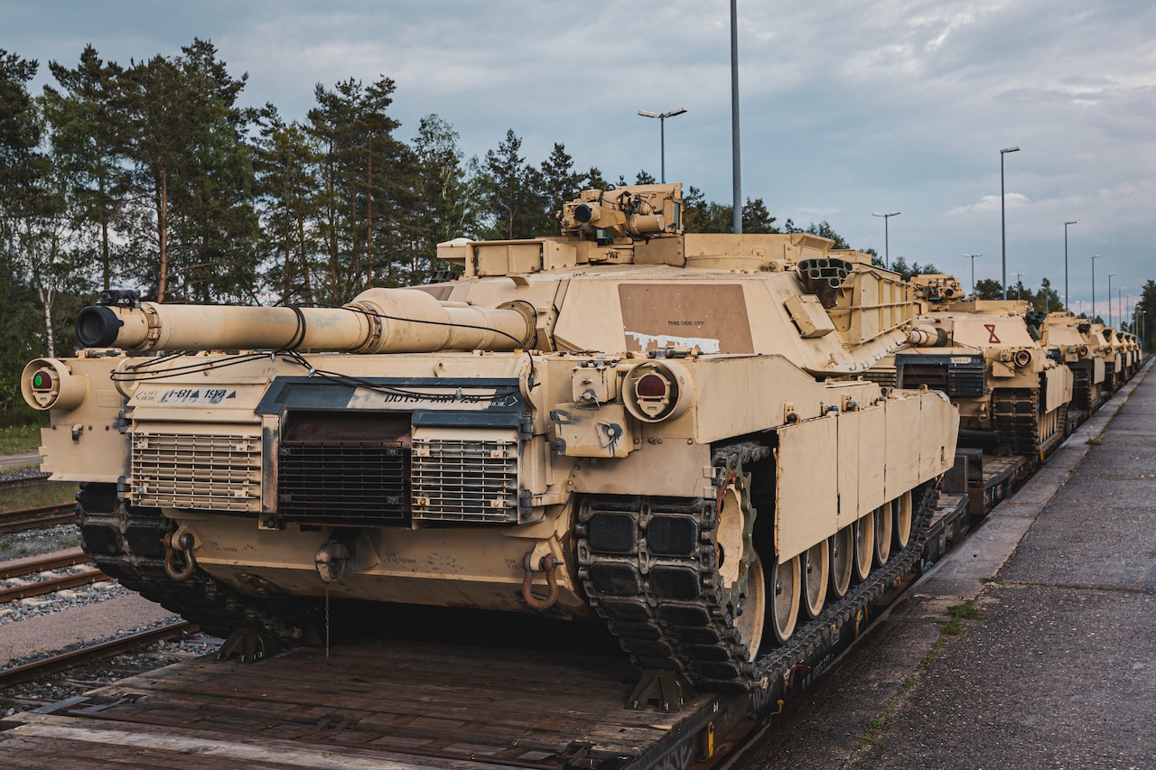 A line of tanks are on a railcar.