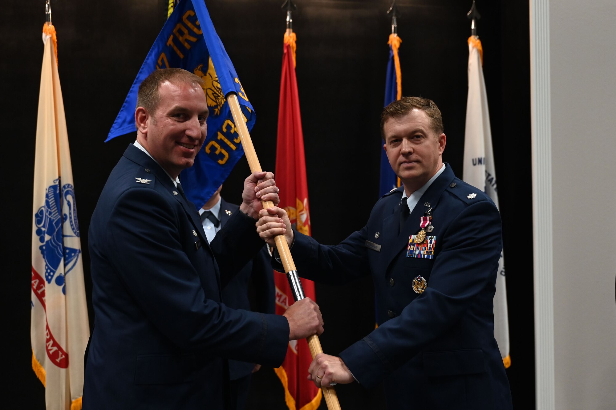 U.S. Air Force Col. Jason Kulchar, 17th Training Group commander, takes the guidon from Lt. Col. Daniel Blackledge, outgoing 313th Training Squadron commander, during the change of command ceremony at the Powell Event Center, Goodfellow Air Force Base, Texas, June 9, 2023. Passing the guidon represents the transfer of leadership responsibilities to the next commander. (U.S. Air Force photo by Airman 1st Class Madison Collier)