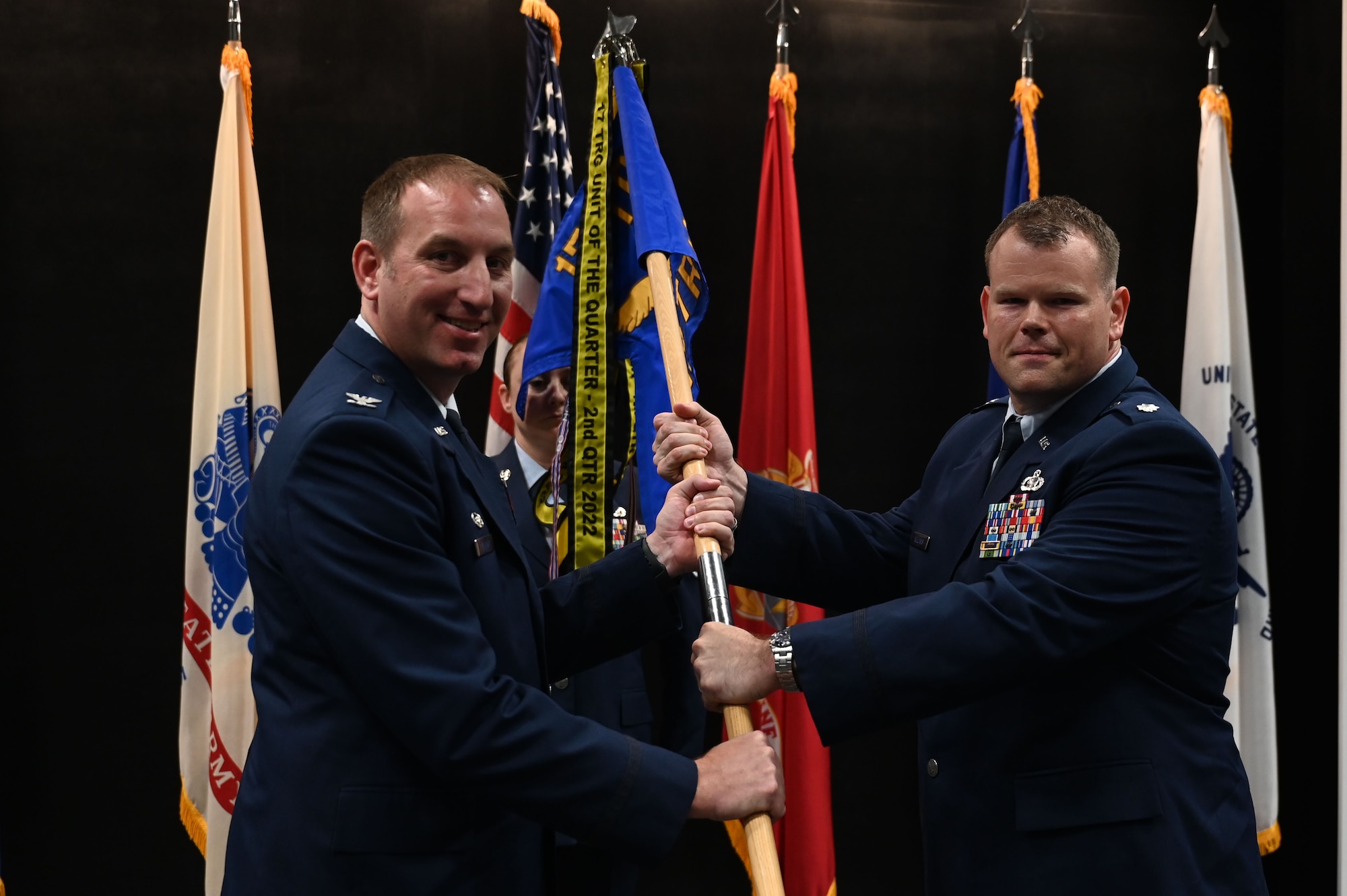 U.S. Air Force Col. Jason Kulchar, 17th Training Group commander, passes the guidon to Lt. Col. Garrett Williams, incoming 313th Training Squadron commander, during the change of command ceremony at the Powell Event Center, Goodfellow Air Force Base, Texas, June 9, 2023. Williams was formerly responsible for daily staff operations and integrating 16th Air Force operations, activities, and investments into the efforts of the United States Cyber Command, the National Security Agency, and other interagency and international partners. (U.S. Air Force photo by Airman 1st Class Madison Collier)