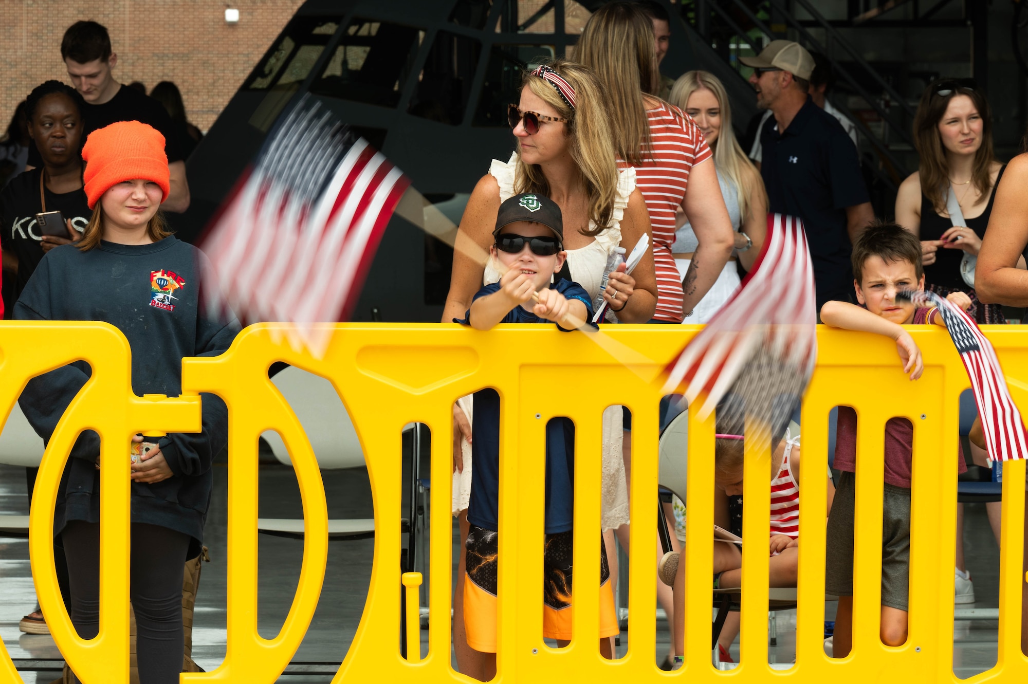 Mark Doerer, spins two American flags in a circle while waiting for his father, Maj. Michael Doerer, 96th Airlift Squadron chief navigator, to arrive home from a three-month deployment at Minnesota-St. Paul Air Reserve Station, Minnesota, June 5, 2023. Approximately 150 934 Airlift Wing Airmen returned home from Djibouti in support of Operation East Africa Counterterrorism’s mission.  (U.S. Air Force photo by Chris Farley)