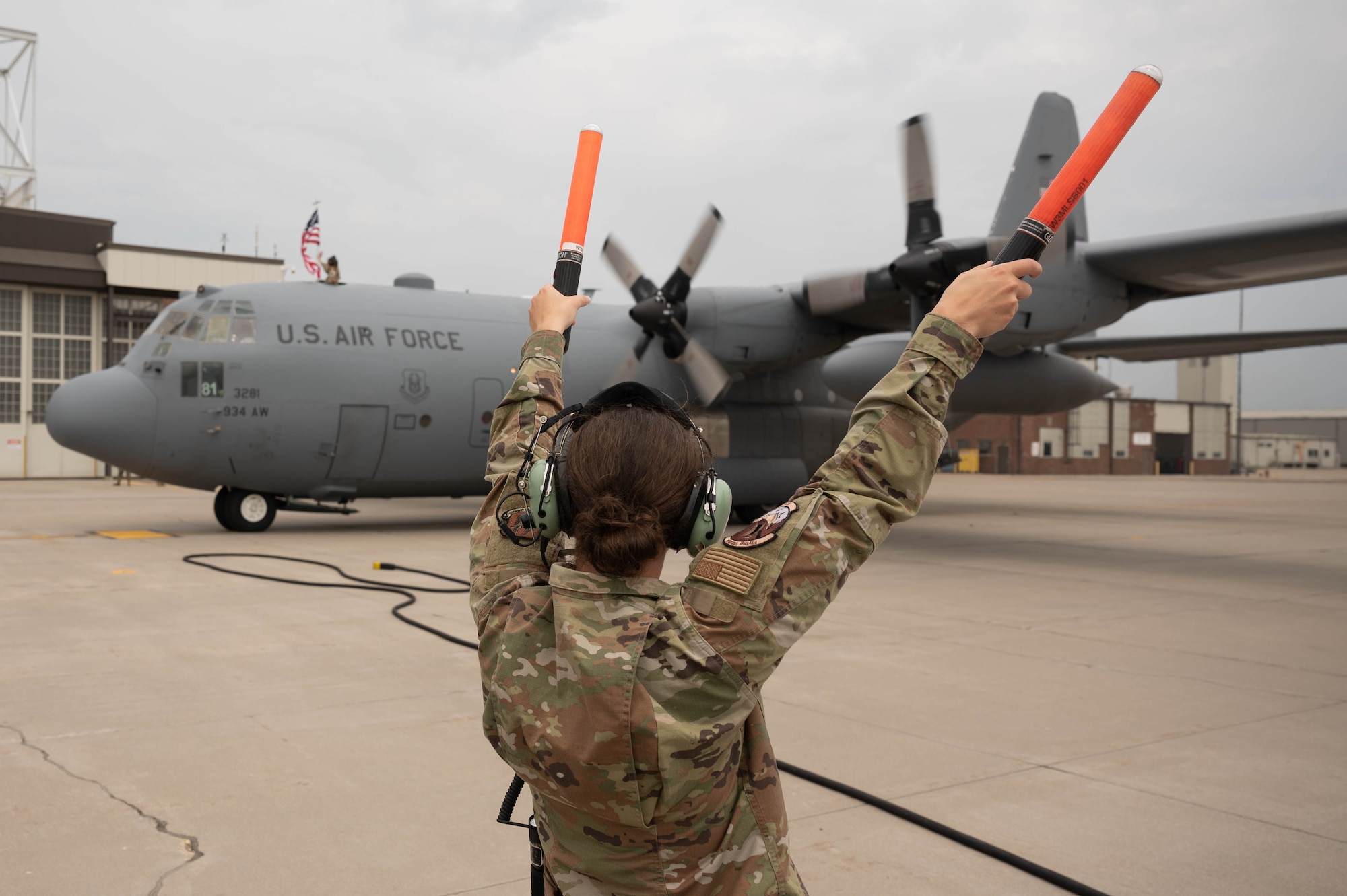 Airman 1st Class Jasmine Best, 934th Maintenance Squadron crew chief, marshals a returning 934th Airlift Wing C-130H Hercules aircraft at Minnesota-St. Paul Air Reserve Station, Minnesota, June 5, 2023. More than 150 934 AW Airmen and multiple C-130s returned home after a three-month deployment  to Djibouti in the Horn of Africa supporting Operation East Africa Counterterrorism's mission. (U.S. Air Force photo by Chris Farley)