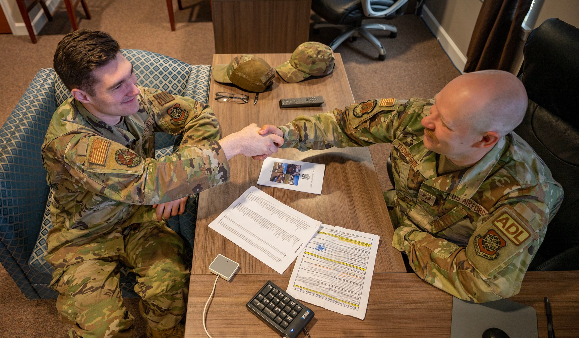 Airman 1st Class Hayden Morris, left, 736th Aircraft Maintenance Squadron crew chief, shakes hands with Tech. Sgt. Adam Thompson, right, 436th Civil Engineer Squadron airman dorm leader, at Dover Air Force Base, Delaware, June 7, 2023. One of Thompson’s duties as an ADL is to out-process Airmen from the unaccompanied dormitories. (U.S. Air Force photo by Airman 1st Class Amanda Jett)