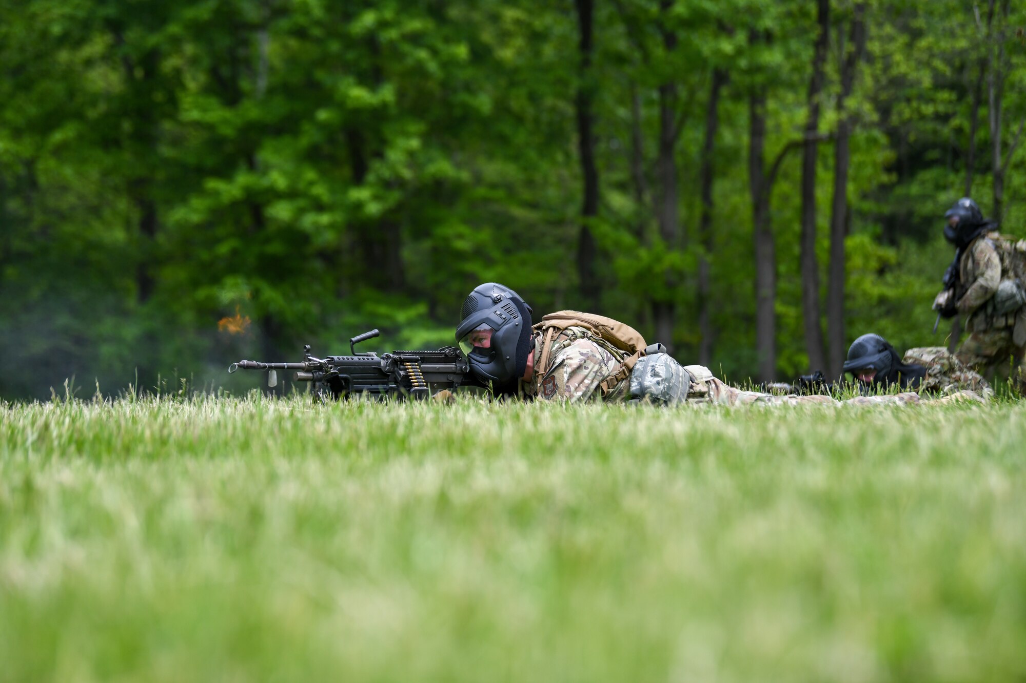 An Air Force Reserve Command Security Forces member fires blank rounds from his M249 light machine gun during an area security operations exercise at the Integrated Defense Leadership Course at Camp James A. Garfield Joint Military Training Center, Ohio, May 19, 2023.
