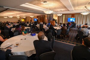 A man thanks the crowd in front of him at a conference.
