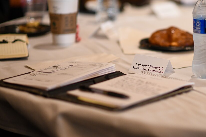 An open notebook lays on a table at a conference.
