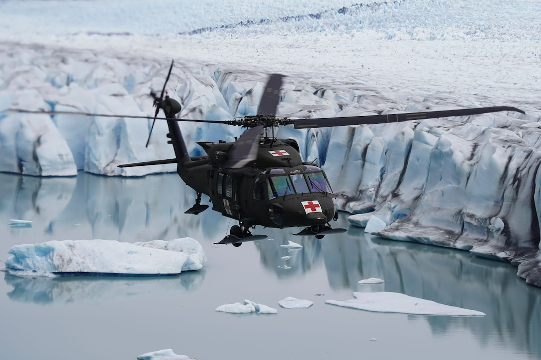 A Black Hawk helicopter flies low over a melting glacier.