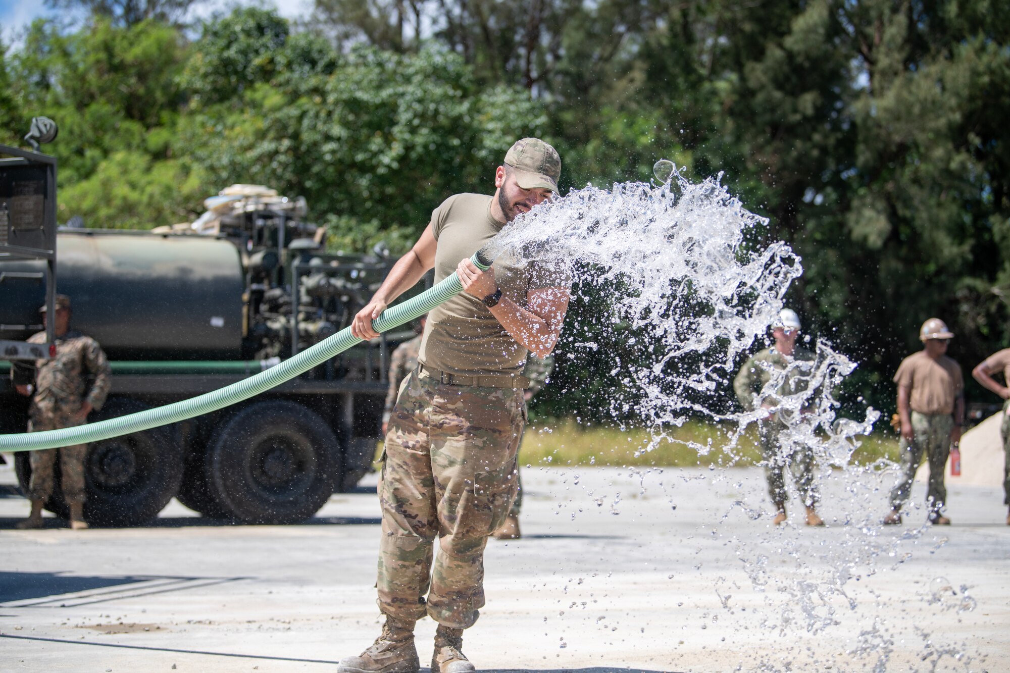 Airman pouring water on concrete mix during RADR exercise
