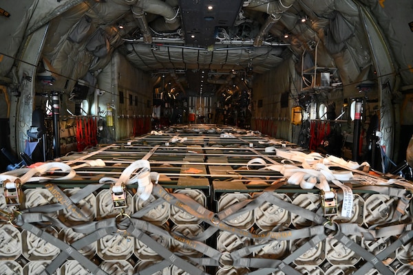 A pallet of weapons is photographed inside a military aircraft.
