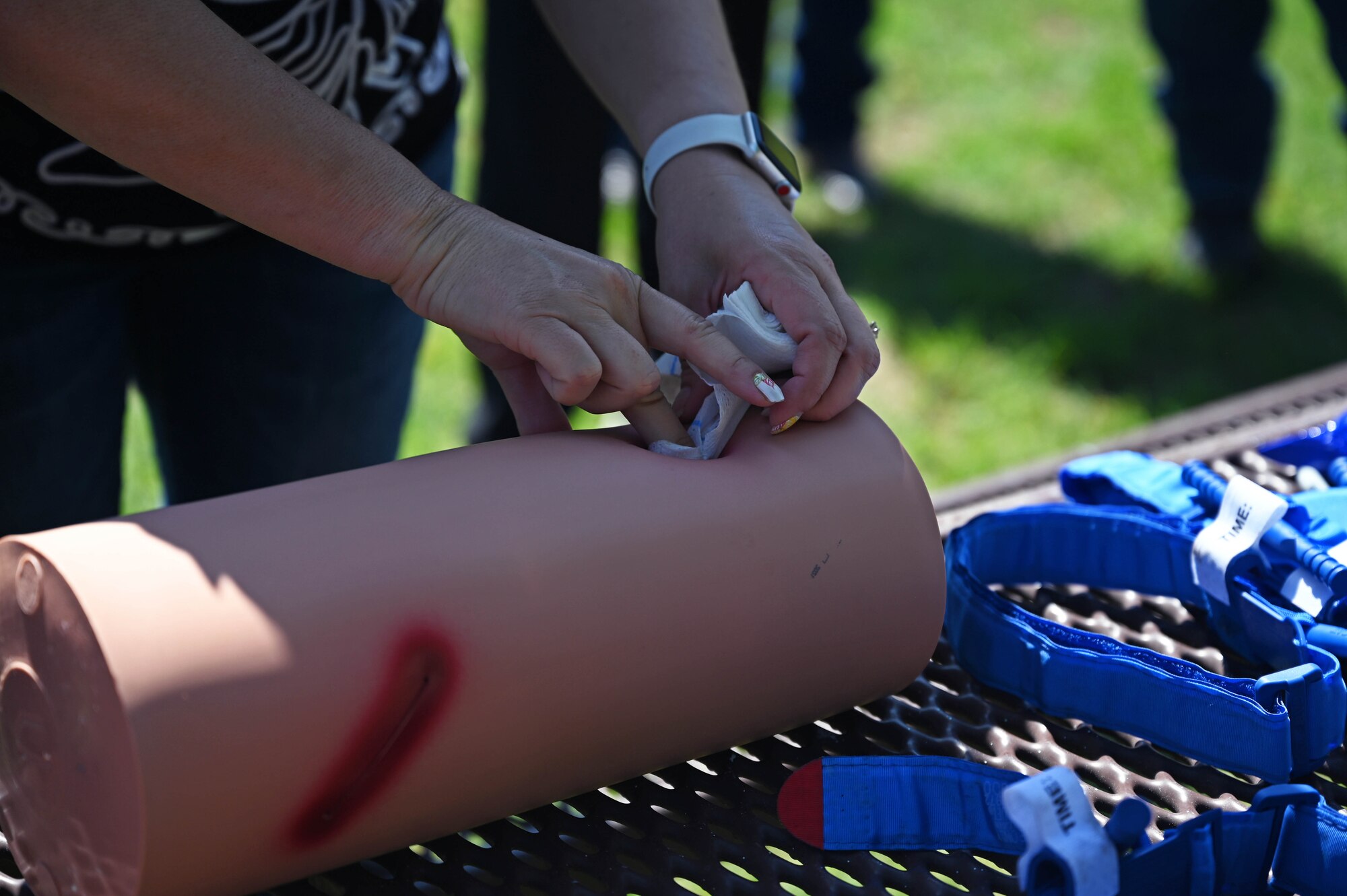 A 17th Training Wing honorary commander, Lynsey Flage, performs Tactical Combat Casualty Care procedure into a simulated wound at Goodfellow Air Force Base, Texas, June 8, 2023. TCCC taught life-saving techniques and strategies for providing the best trauma care on the battlefield. (U.S. Air Force photo by Senior Airman Sarah Williams)