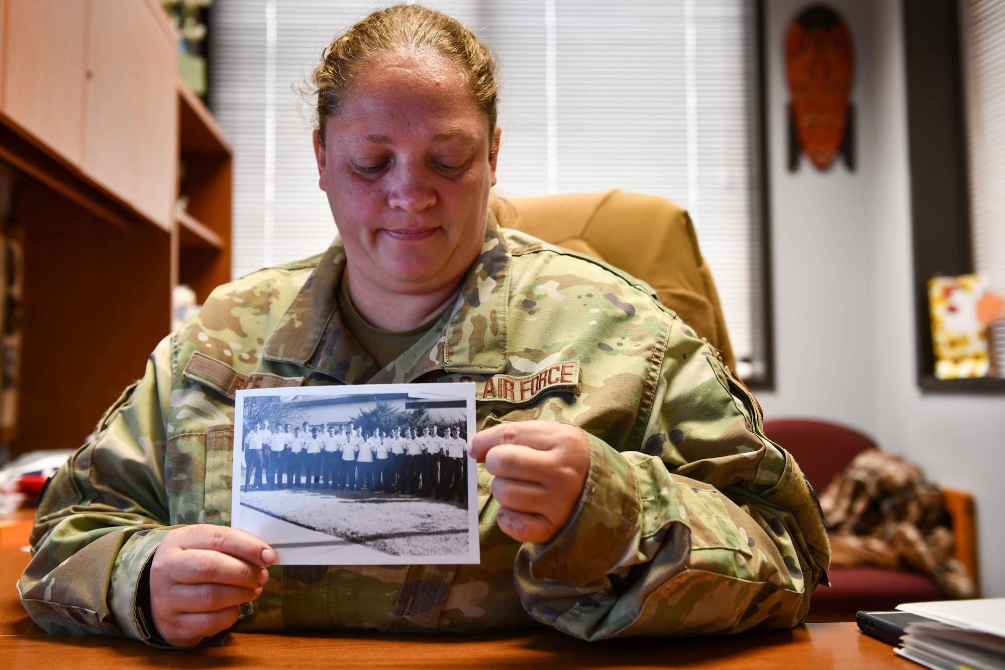 U.S. Air Force Tech. Sgt. Crystal Rice, 97th Force Support Squadron manpower and organization noncommissioned officer in charge, poses with a photo of her father’s squadron at Altus Air Force Base (AFB), Oklahoma, June 7, 2023. Altus AFB was Rice’s father’s first duty station and now it is Rice’s last duty station. (U.S. Air Force photo by Airman 1st Class Kari Degraffenreed)