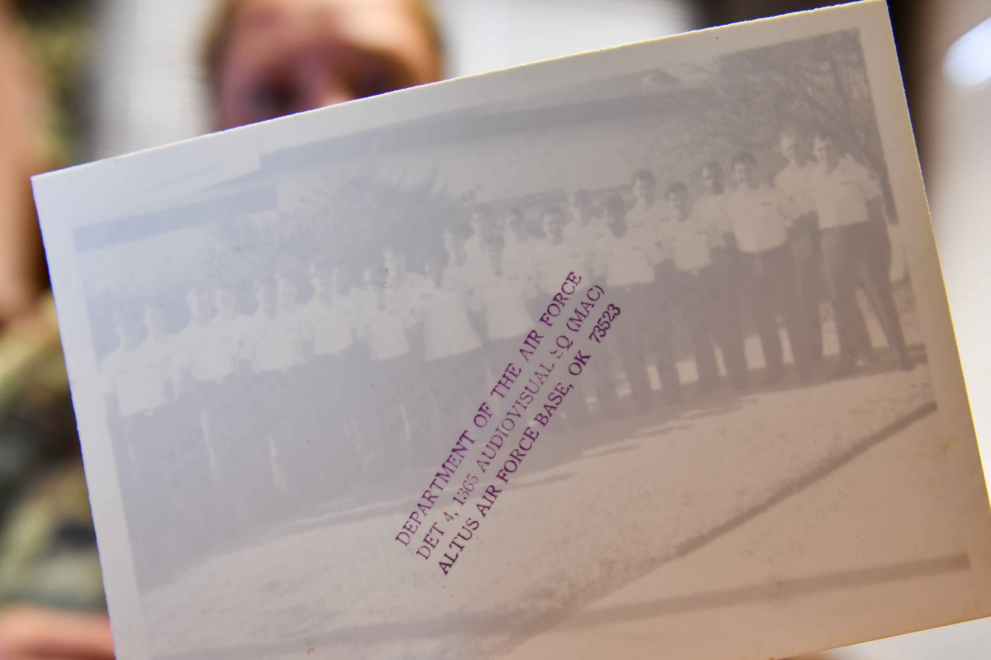 U.S. Air Force Tech. Sgt. Crystal Rice, 97th Force Support Squadron manpower and organization noncommissioned officer in charge, holds up the back of a photo of her father’s squadron at Altus Air Force Base (AFB), Oklahoma, June 7, 2023. Rice was born in a United States Air Force Hospital at Altus AFB in 1980. (U.S. Air Force photo by Airman 1st Class Kari Degraffenreed)
