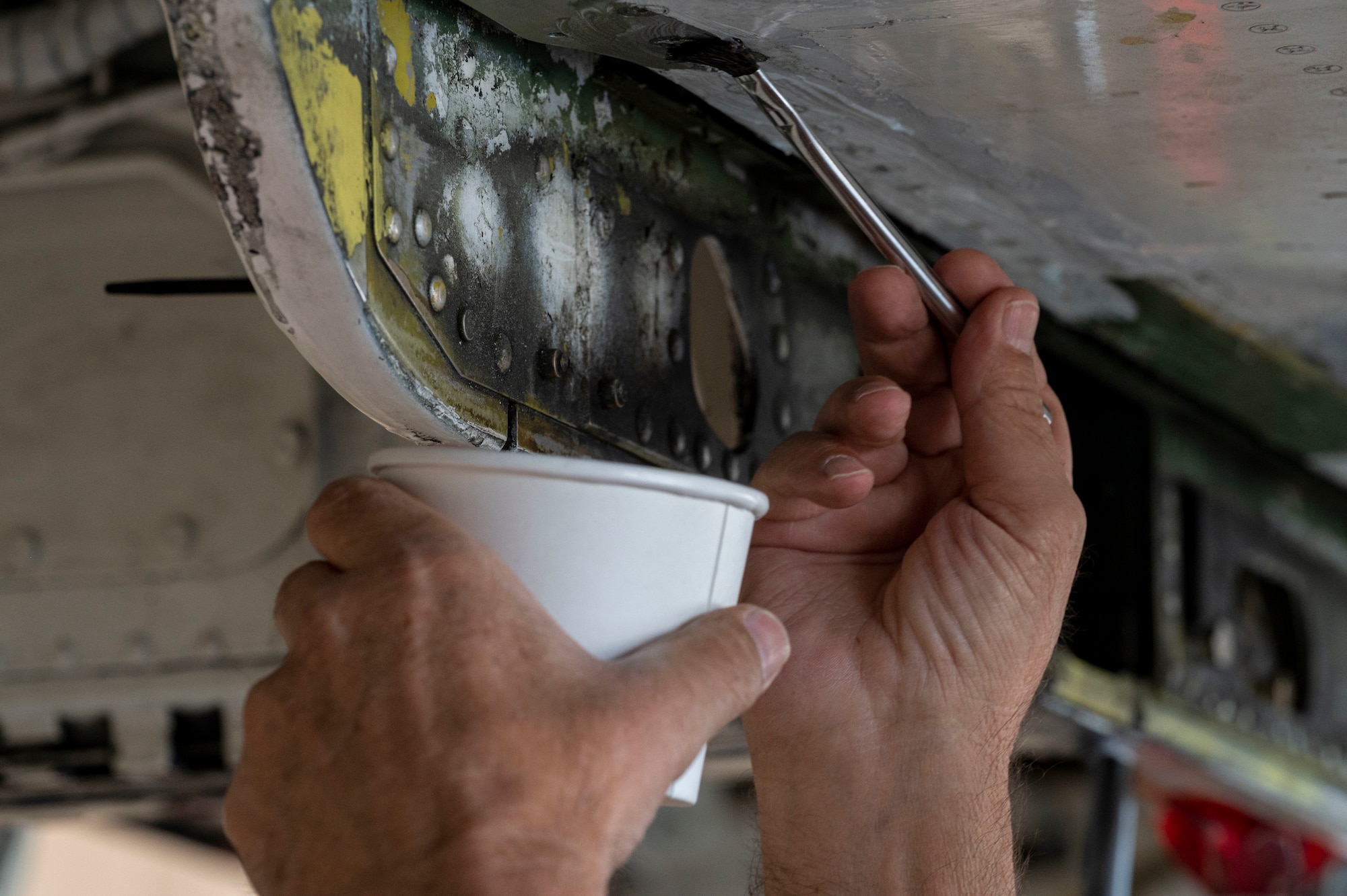 A T-38 Aircraft Maintenance Program contractor paints the underside of a T-38A/B Talon at Holloman Air Force Base, New Mexico, June 8, 2023.