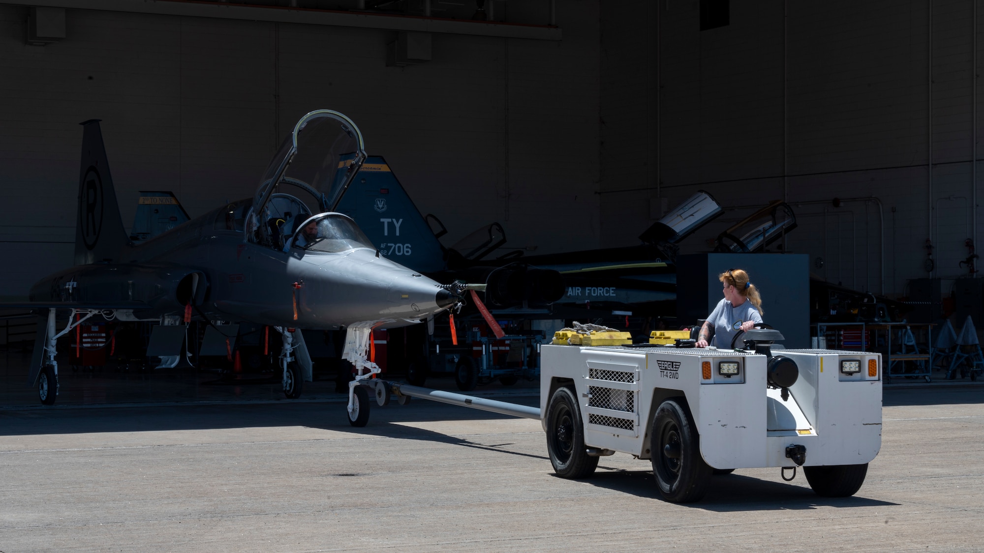 Tina McLain, T-38 Aircraft Maintenance Program team lead, tows a T-38A/B Talon out of a hangar at Holloman Air Force Base, New Mexico, June 8, 2023.