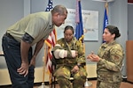Tech. Sgt. Kailani Trainor-Bird, right, aerospace medical technician with Detachment 1 of the Wisconsin Air National Guard's 115th Medical Group, reviews Tactical Combat Casualty Care procedures with Warrant Officer Jerry Aihi and Maj. Louisa Wanma of the Papua New Guinea Defense Force June 6, 2023, at Truax Field in Madison, Wis. The training opportunity between the Wisconsin and Papua New Guinea medical professionals was part of the National Guard State Partnership Program,