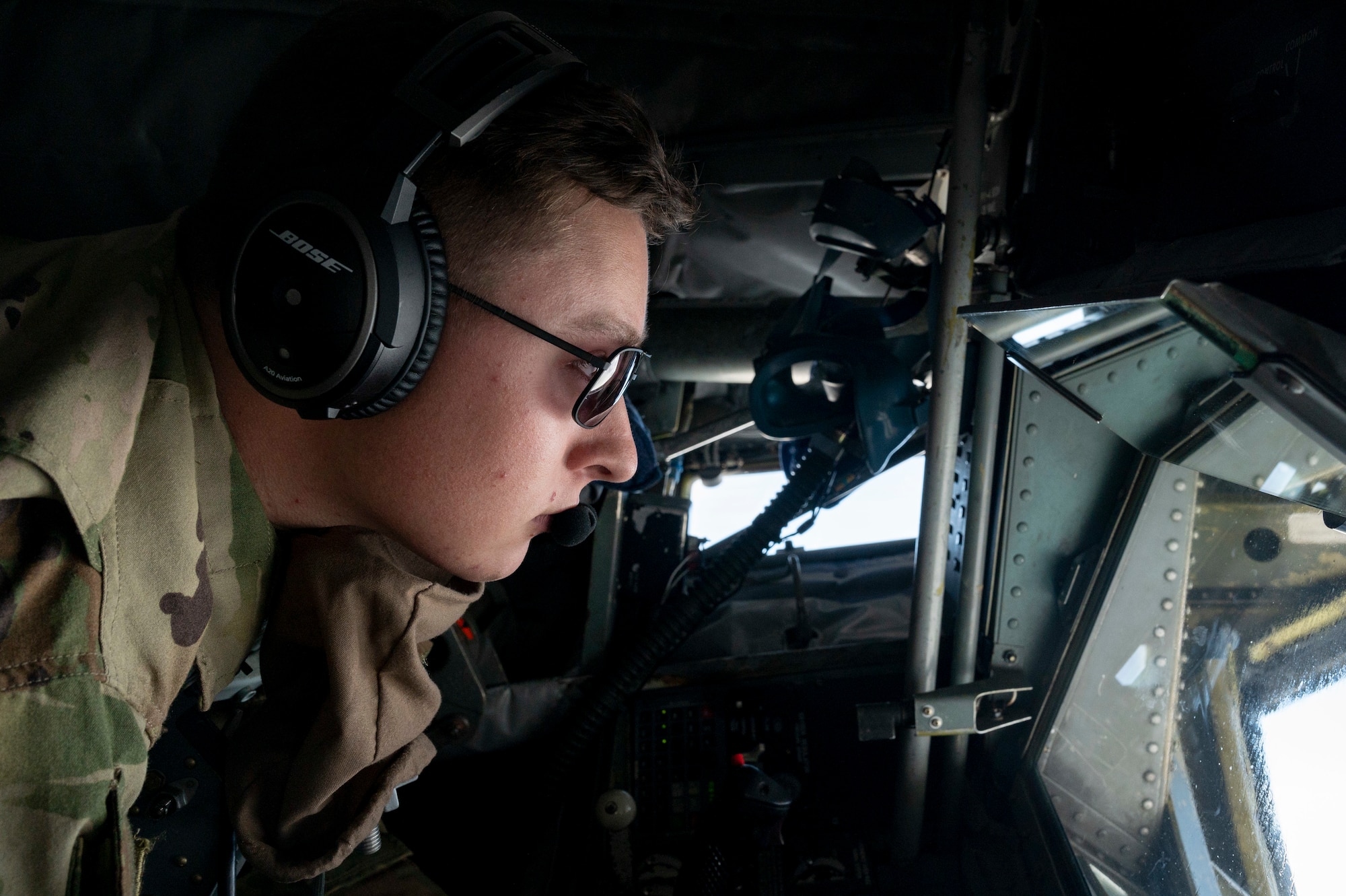 Photo of an Airman operating a refueling boom in an aircraft