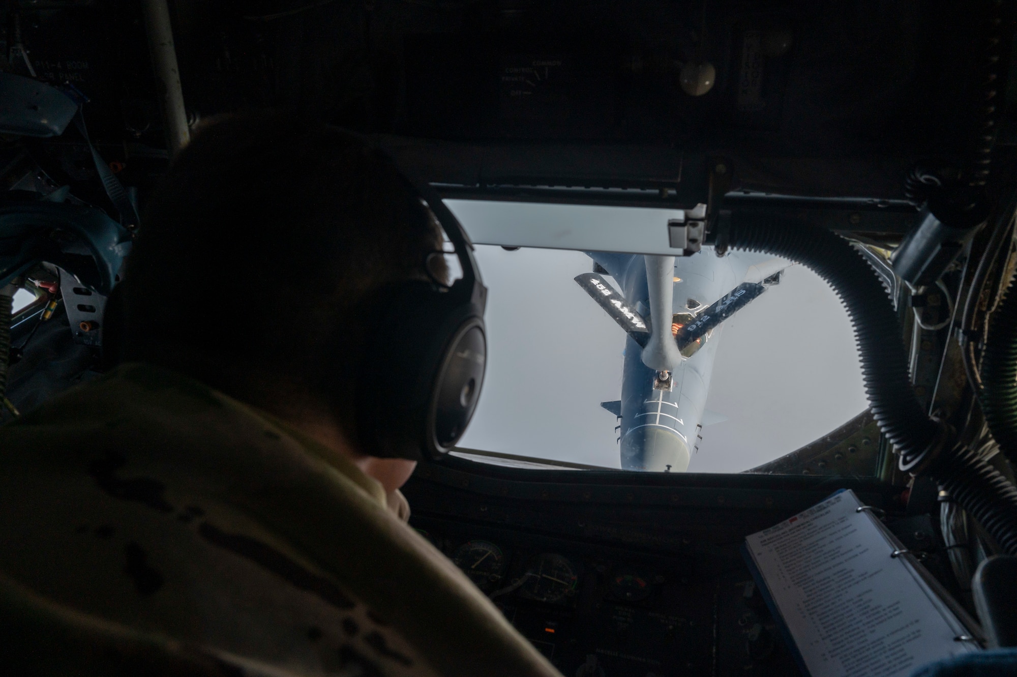 Photo of an Airman operating a refueling boom inside an aircraft