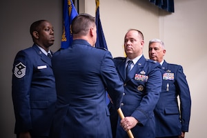 U.S. Air Force Col. Joel Sattazahn, right, 193rd Special Operations Mission Group commander, accepts the unit guidon from Col. Edward Fink, 193rd Special Operations Wing commander, during a change of command ceremony June 10 2023, in Middletown, Pennsylvania.