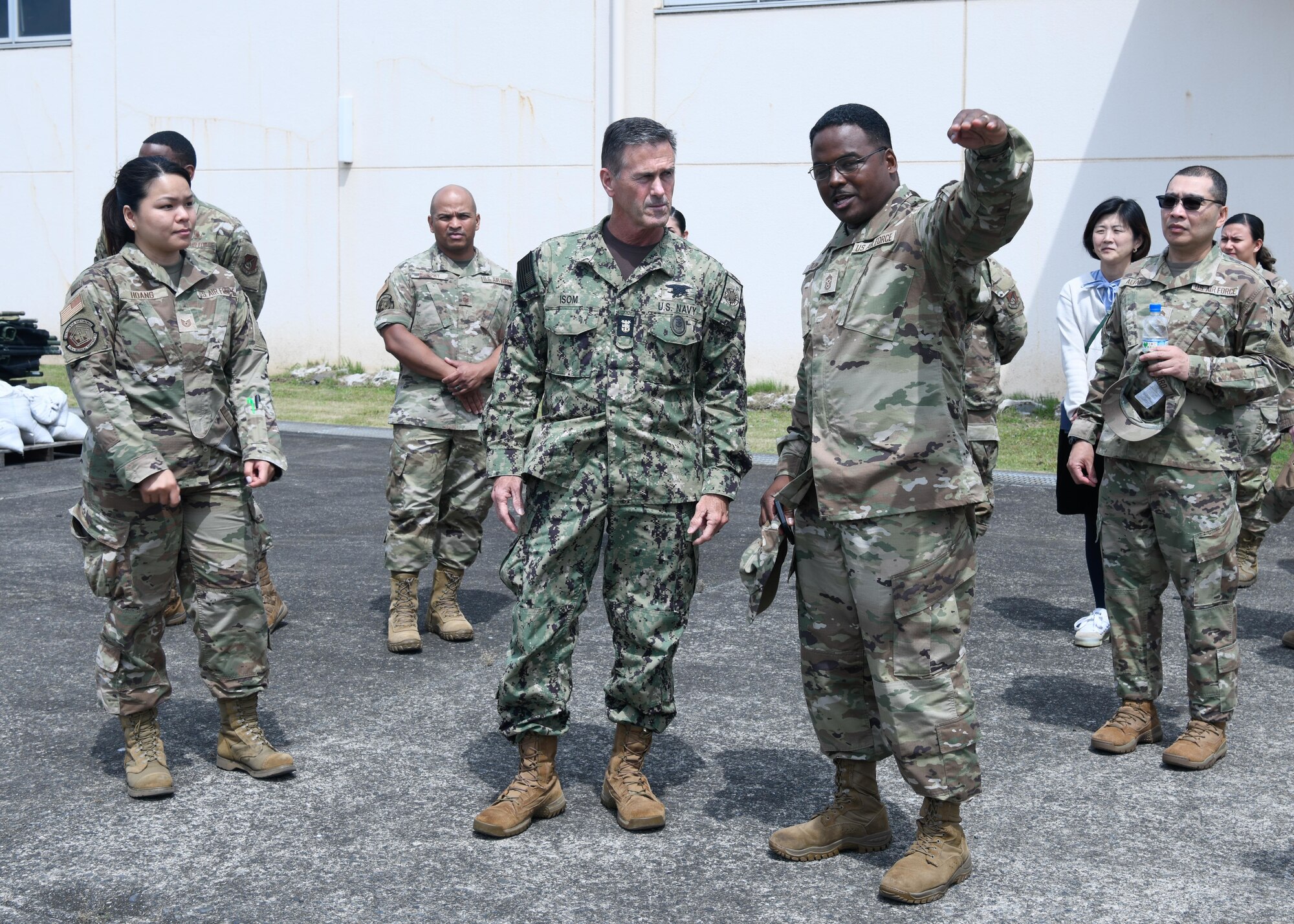 Service members stand outside a building.