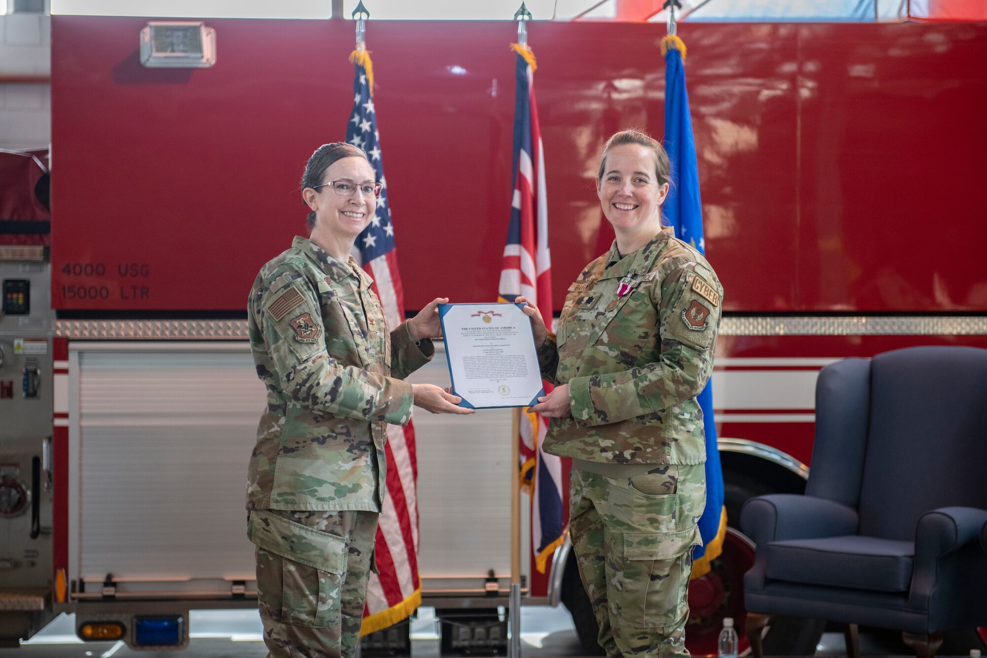 Col. Valerie Long, 423d Air Base Group commander, left, presents a medal of meritorious service to Lt. Col. Erica Balfour, 423d Communications Squadron outgoing commander, at RAF Alconbury