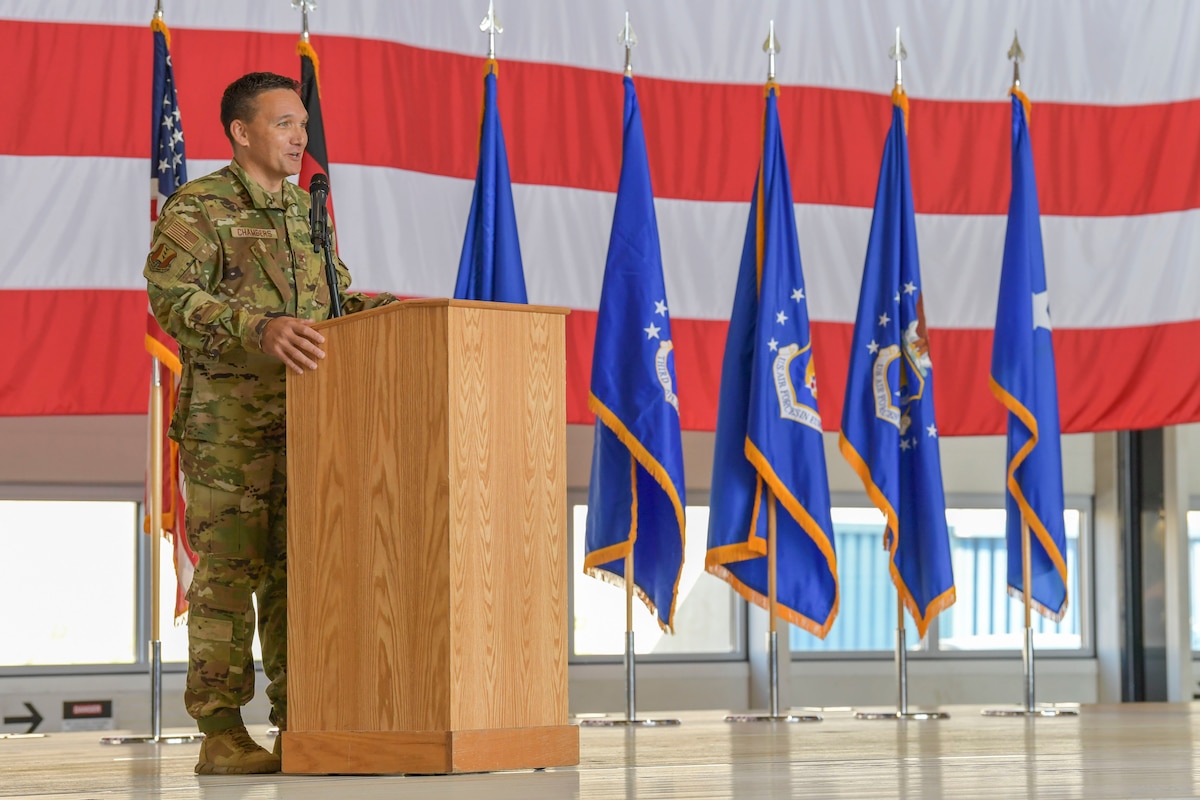 U.S. Air Force Col. Jason Chambers, 406th Air Expeditionary Wing commander, addresses his new wing during the 406th AEW activation and assumption of command ceremony at Ramstein Air Base, Germany, June 9, 2023. The 406th AEW will continue the now-deactivated 435th AEW’s mission of conducting tactical airlift, personnel recovery and casualty evacuation, and multi-role attack operations.