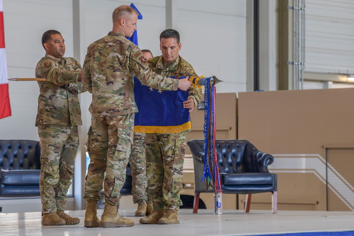 U.S. Air Force Maj. Gen. Derek France, 3rd Air Force commander, left, and Col. Bryan Callahan, 435th Air Expeditionary Wing commander, right, roll and sheath the 435th AEW wing flag during a wing deactivation ceremony at Ramstein Air Base, Germany, June 9, 2023. The deactivation was part of a larger ceremony including the activation of the 406th Air Expeditionary Wing, assumption of command of the 406th AEW and change of command of the 435th Air Ground Operations Wing.