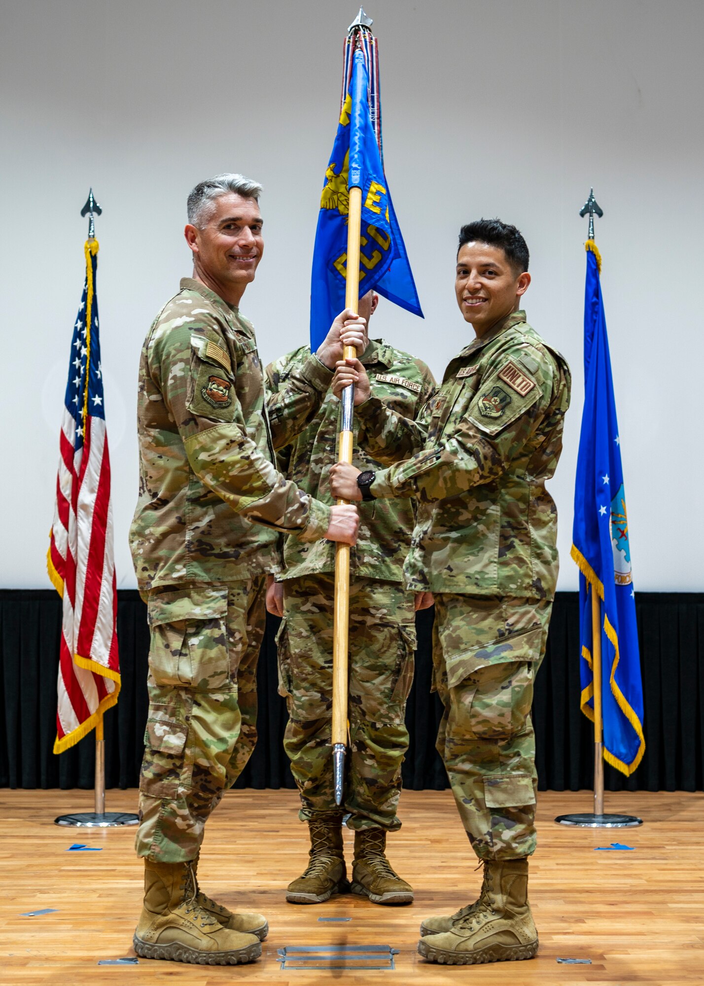 Col. George Buch, 386th Air Expeditionary Wing commander, passes the guidon to Maj. Moises Guzman, incoming 386th ECONS commander
