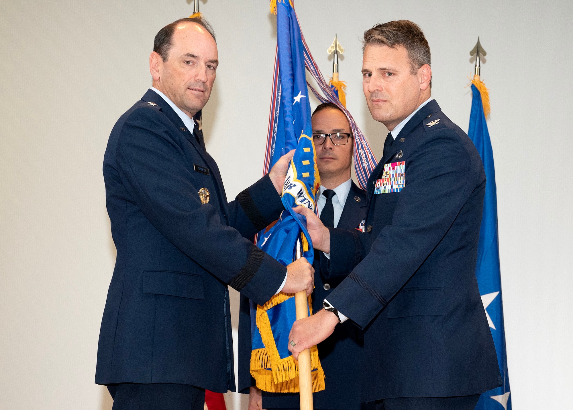 U.S. Air Force Lt. Gen. Kevin B. Kennedy, 16th Air Force (Air Forces Cyber) commander, receives the 70th Intelligence, Surveillance and Reconnaissance Wing guidon from U.S. Air Force Col. Craig S. Miller, 70th ISRW commander, during a Change of Command Ceremony June 9, 2023, at Fort George G. Meade, Maryland. Kennedy was the presiding officer for the ceremony, which Miller relinquished command of the 70th ISRW to U.S. Air Force Col. Celina E. Noyes. (U.S. photo by Staff Sgt. Kevin Iinuma)