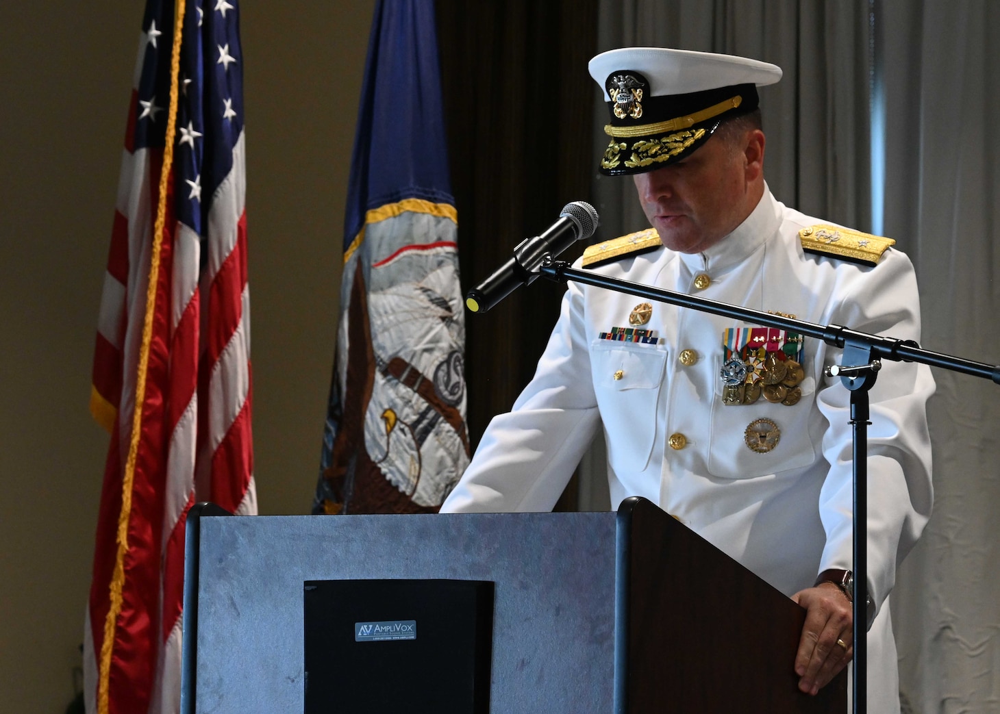 Rear Adm. Martin Muckian reads his orders during a change of command ceremony onboard Naval Station Norfolk.