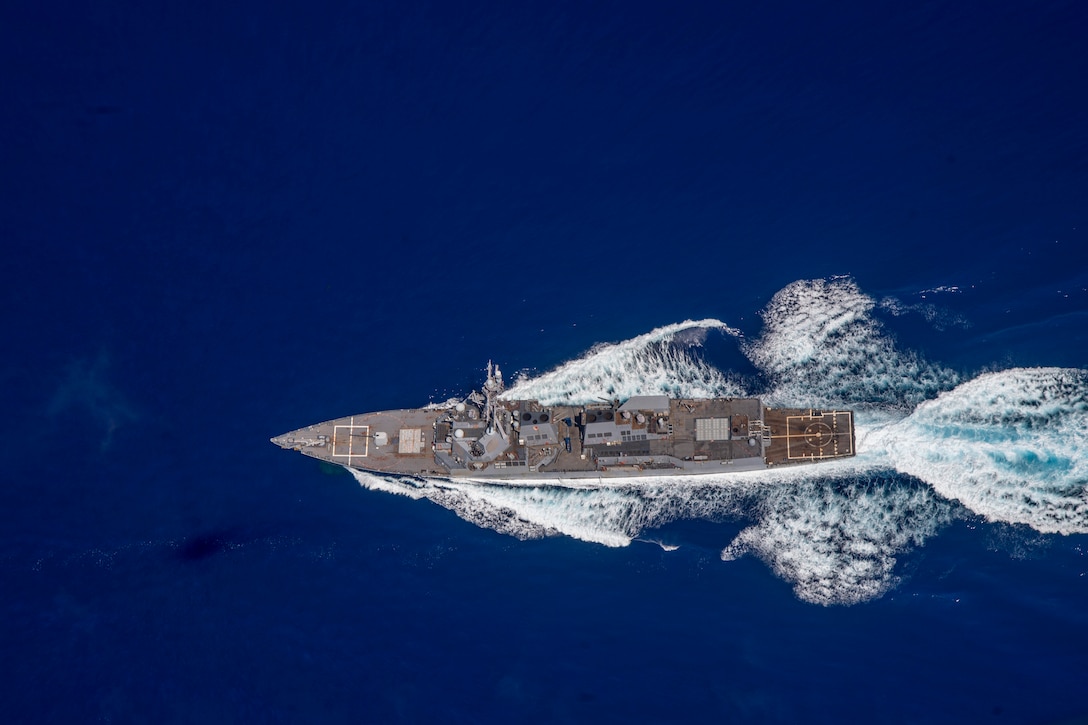 Aerial view of a Navy ship sailing in the Pacific Ocean.