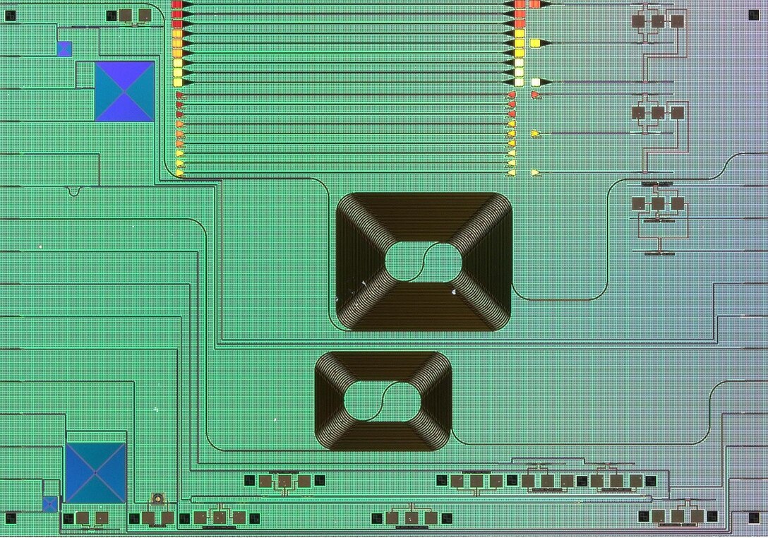 Top-down view of the AIM/Spark Photonics 3rd generation active education and workforce development photonic integrated circuit (EWD PIC) chip as seen through an optical microscope at the Lab for Education & Application Prototypes (LEAP) facility located at Worcester Polytechnic Institute (WPI). The lab is a part of the LEAP Network, established by the Commonwealth of Massachusetts' M2I2 program to support AIM Photonics.