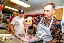 Logistics Specialist 1st Class Marcus Martin, assigned to Arleigh Burke-class guided-missile destroyer, USS John S. McCain (DDG 56), learns how to make a "Homer" at Voodoo Doughnut during Portland Fleet Week on June 9, 2023. Portland Fleet Week is a time-honored celebration of the sea services and provides an opportunity for the citizens of Oregon to meet Sailors, Marines and Coast Guardsmen, as well as witness firsthand the latest capabilities of today’s maritime services. (U.S. Navy photo by Mass Communication Specialist 2nd Class Gwendelyn L. Ohrazda)