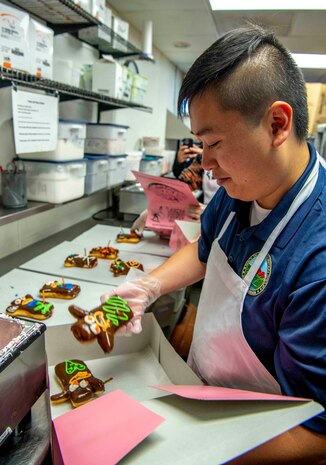 Machinist's Mate (Nuclear) 1st Class Peter Ho, assigned to Navy Talent Acquisition Group (NTAG) Portland, boxes doughnuts at Voodoo Doughnut during Portland Fleet Week on June 9, 2023. Portland Fleet Week is a time-honored celebration of the sea services and provides an opportunity for the citizens of Oregon to meet Sailors, Marines and Coast Guardsmen, as well as witness firsthand the latest capabilities of today’s maritime services. (U.S. Navy photo by Mass Communication Specialist 2nd Class Gwendelyn L. Ohrazda)