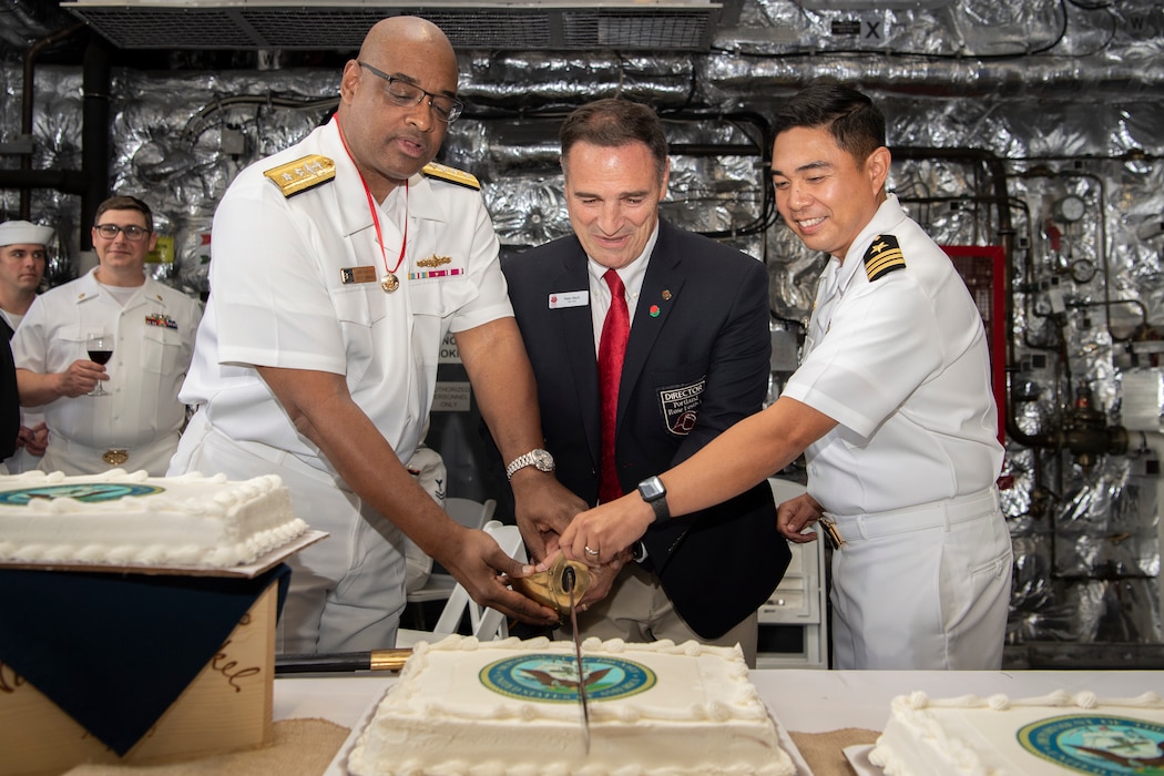 Rear Adm. Larry Watkins, Deputy Commander, assigned to U.S. Third Fleet, Fleet Chair Peter Mack, Portland Rose Festival Director and Cmdr. Brian Bungay, commanding officer, assigned to Independence-variant littoral combat ship, USS Kansas City (LCS 22), slices a cake together for a U.S. Navy reception during Portland Fleet Week in Portland, Oregon, June 9, 2023. Portland Fleet Week is a time-honored celebration of the sea services and provides an opportunity for the citizens of Oregon to meet Sailors, Marines and Coast Guardsmen, as well as witness firsthand the latest capabilities of today’s maritime services. (U.S. Navy photo by Mass Communication Specialist Seaman Sophia H. Bumps)