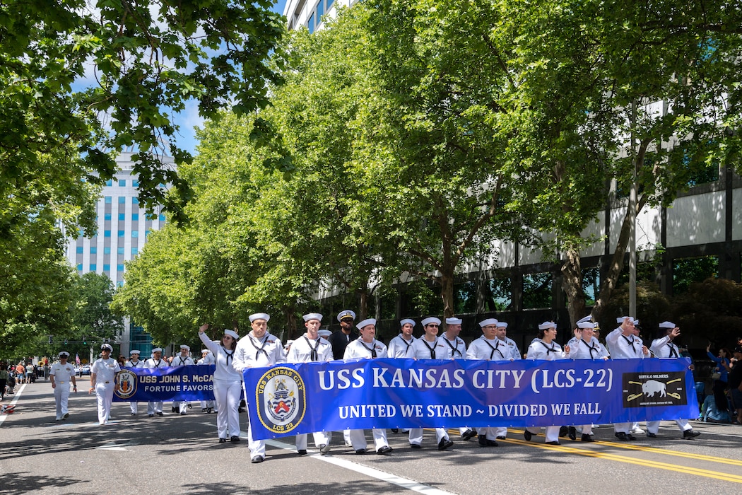 Sailors assigned to Independence-variant littoral combat ship, USS Kansas City (LCS 22) and Arleigh Burke-class guided-missile destroyer, USS John S. McCain (DDG 56), marches  together at the annual Rose Festival Parade during Portland Fleet Week in Portland, Oregon, June 10, 2023. Portland Fleet Week is a time-honored celebration of the sea services and provides an opportunity for the citizens of Oregon to meet Sailors, Marines and Coast Guardsmen, as well as witness firsthand the latest capabilities of today's maritime services. (U.S. Navy photo by Mass Communication Specialist Seaman Sophia H. Bumps)