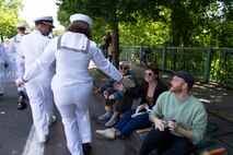 Sailors assigned to Independence-variant littoral combat ship, USS Kansas City (LCS 22), interact with the crowd at the annual Rose Festival Parade during Portland Fleet Week in Portland, Oregon, June 10, 2023. Portland Fleet Week is a time-honored celebration of the sea services and provides an opportunity for the citizens of Oregon to meet Sailors, Marines and Coast Guardsmen, as well as witness firsthand the latest capabilities of today's maritime services. (U.S. Navy photo by Mass Communication Specialist Seaman Sophia H. Bumps)