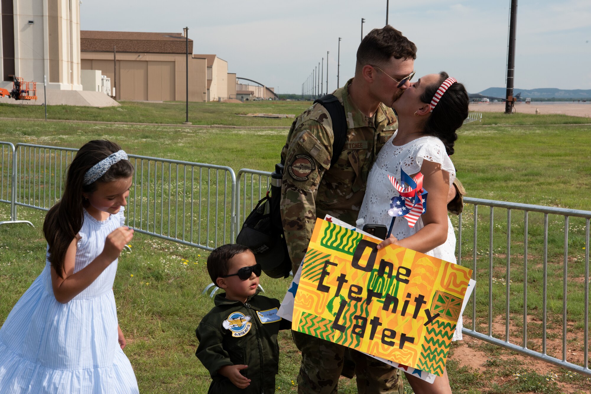 A U.S. Air Force Airman from the 317th Airlift Wing kisses his wife after returning from a six-month deployment at Dyess Air Force Base, Texas, June 7, 2023. The 317th AW leadership and family members gathered to welcome home the Airmen after their return from supporting U.S. Central Command taskings. (U.S. Air Force photo by Airman 1st Class Alondra Cristobal Hernandez)