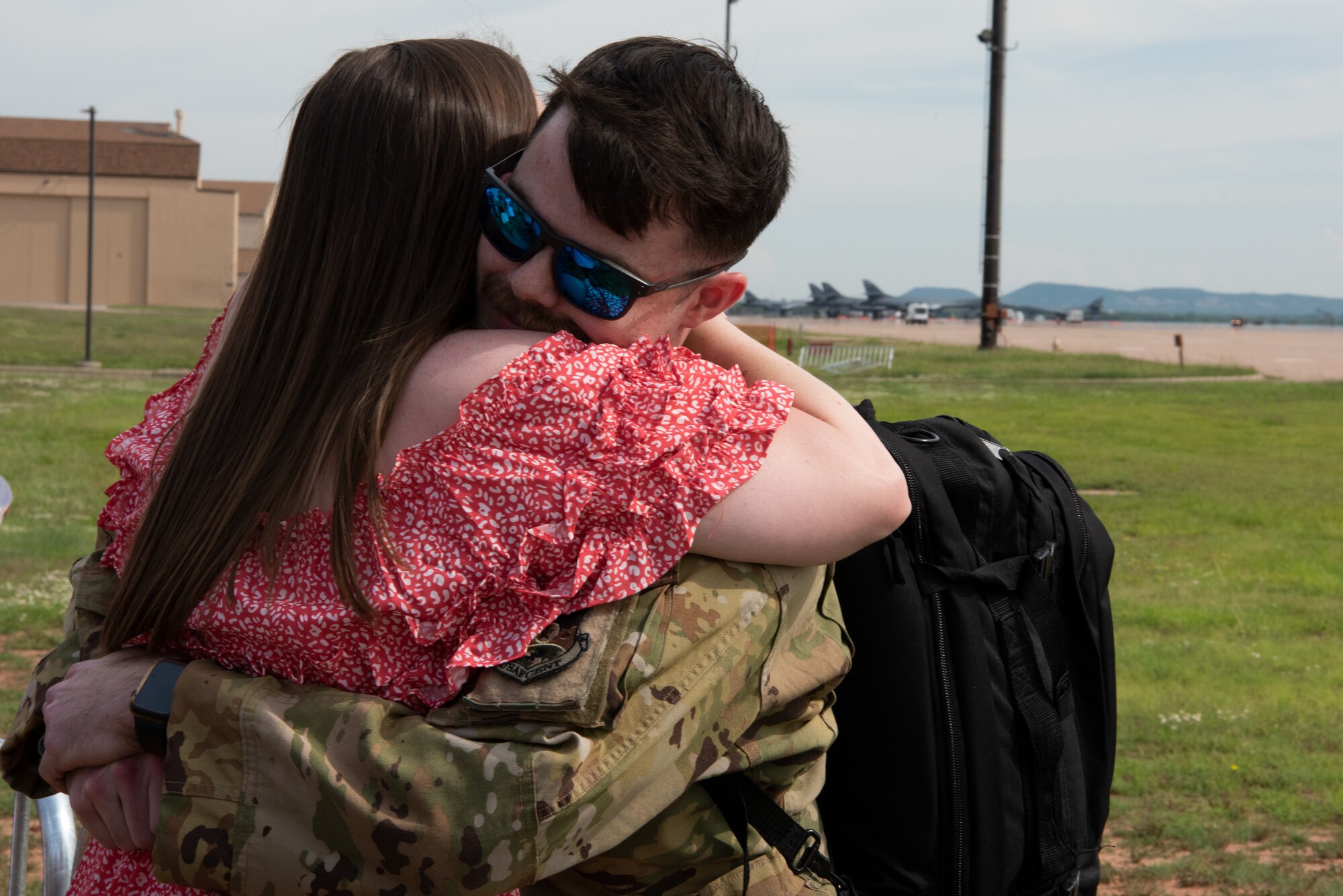 A U.S. Air Force Airman from the 317th Airlift Wing embraces a family member while returning from six-month deployment at Dyess Air Force Base, Texas, June 7, 2023. The 317th AW leadership and family members gathered to welcome home the Airmen after their return from supporting U.S. Central Command taskings. (U.S. Air Force photo by Airman 1st Class Alondra Cristobal Hernandez)