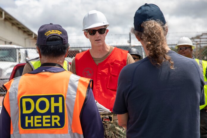 U.S. Navy Lt. Regan Roshetko, assigned to Joint Task Force-Red Hill (JTF-RH), briefs a representative from the Hawaii Department of Health’s (DOH) Hazard Evaluation and Emergency Response Office, and a representative from the U.S. Environmental Protection Agency (EPA), before beginning a spill response exercise on Joint Base Pearl Harbor-Hickam, Hawaii, June 8, 2023.