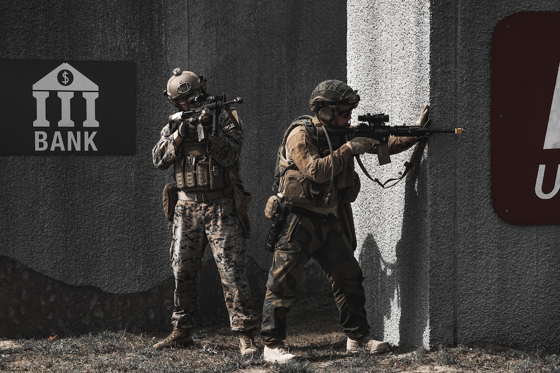 U.S Marine Corps Capt. Quinton Boyed, field artillery officer, 2d Air Naval Gunfire Liaison Company, II Marine Expeditionary Force Information Group, provides security with Norwegian Armed Forces at the Outdoor Infantry Immersion Trainer on Marine Corps Base Camp Lejeune, North Carolina, May 18, 2023. The OIIT provided Marines and international partners with scenario based realistic training, creating a fully immersive environment using role players, pyrotechnics, subject matter experts, and sound and smell generators.