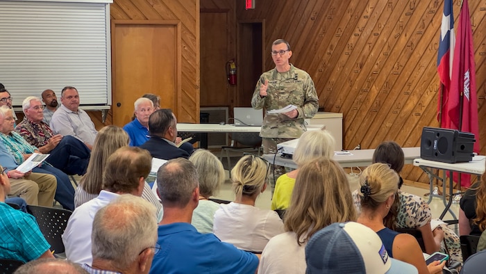 a man is standing in front of a crowd talking