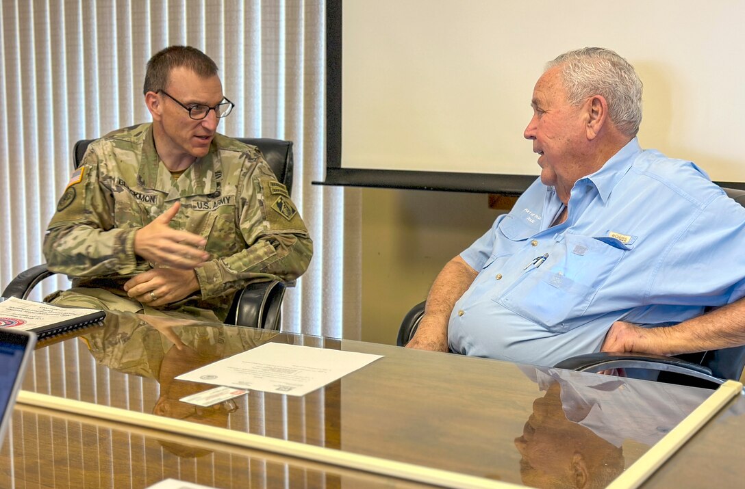 two people are seated at a table and around a table while talking