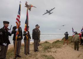 The 1st Infantry Division color guard observes as a flyover is conducted during the Charles Shay Indian Memorial Ceremony, in Saint-Laurent-Sur-Mer, France, June 5, 2023. Past and present 1st Infantry Division Soldiers and Native American veterans gathered to commemorate U.S. Army veteran Master Sgt. Charles Shay, former Big Red One Soldier and a Penobscot Tribe member, for his efforts during D-Day 79 years ago. (U.S. Army photo by Pfc. Daniela Lechuga)