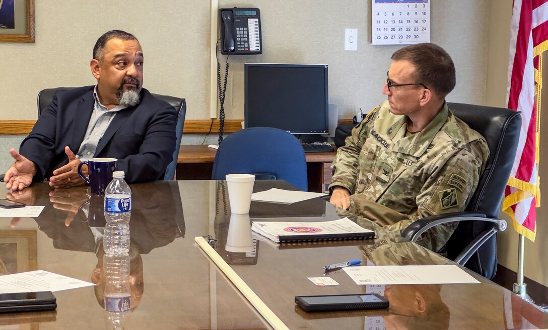 two people are seated at a table talking