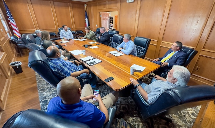 people are seated at a long table talking