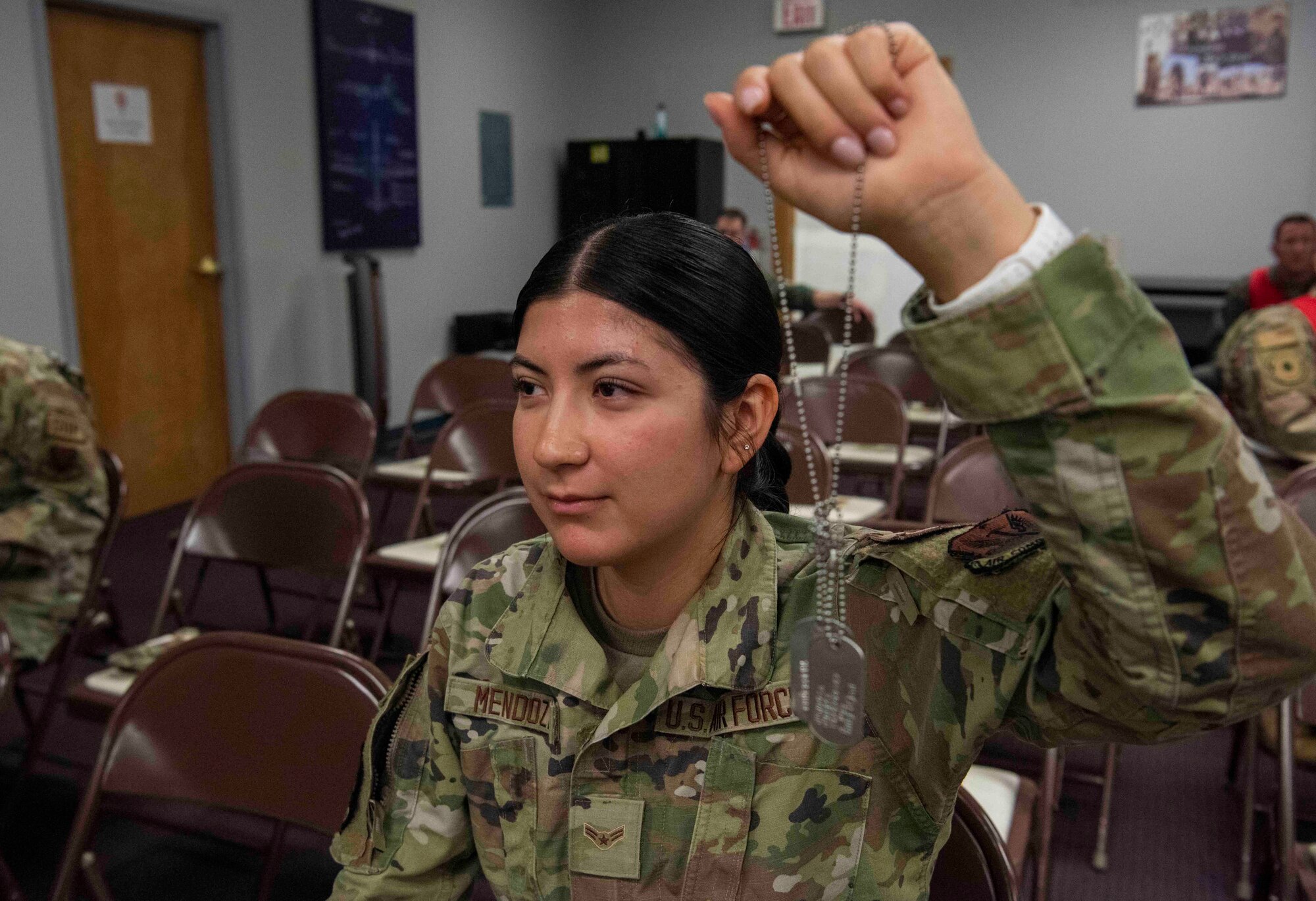 Airmen holds up dog tag